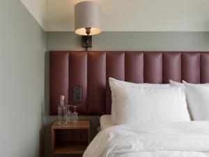 a bedroom with a red headboard and a white bed at Elite Stadshotellet Växjö in Växjö