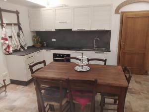 a kitchen with a wooden table and white cabinets at MAGNOLIA in Cortona