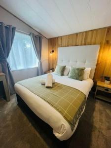 a bedroom with a large bed with a large window at Huckleberry Lodge with Hot Tub in York