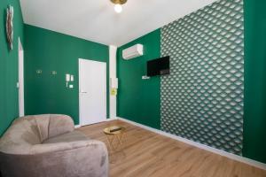 salon z zielonymi ścianami i krzesłem w obiekcie Welcomeagen*Le Parrain*Clim*Fibre w mieście Agen