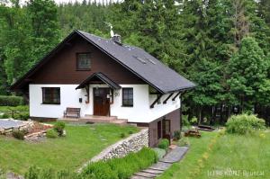 a small white house with a black roof at Ubytování U Rohelů in Karlova Studánka