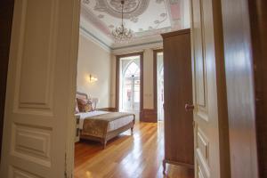 a bedroom with a bed and a chandelier at Dom José Alojamentos by Guestify in Guimarães