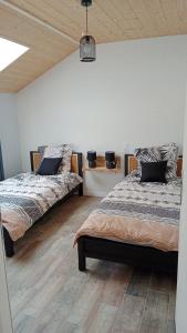 Duas camas num quarto com pisos em madeira em Gîte des Roches em La Chaux-du-Dombief