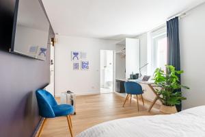 sypialnia z łóżkiem, 2 niebieskimi krzesłami i biurkiem w obiekcie Calme & Chic bleu - Proche gare et centre w mieście Dijon