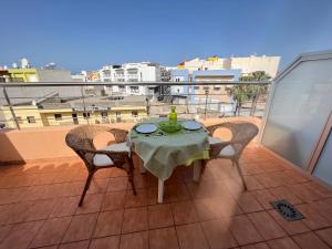 een tafel en stoelen op een balkon met uitzicht bij Apartamentos Playa San Juan Tenerife in Playa de San Juan