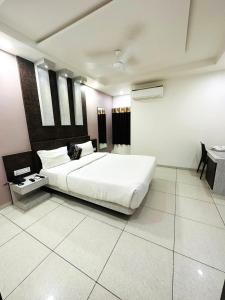 a bedroom with a large white bed in a room at The Sky Comfort Hotel Parth Inn in Dwarka