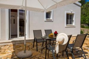 eine Terrasse mit einem Tisch mit Stühlen und einem Sonnenschirm in der Unterkunft Kabos house in Mastorátika