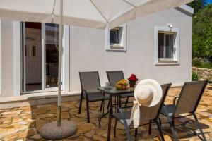 a patio with a table with chairs and an umbrella at Kabos house in Mastorátika