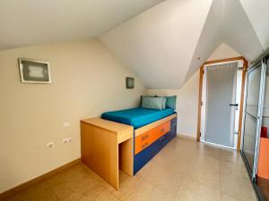 een kamer met een bed en een bureau op zolder bij Apartamentos Playa San Juan Tenerife in Playa de San Juan