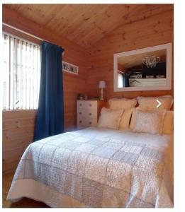 ein Schlafzimmer mit einem Bett in einer Holzhütte in der Unterkunft tranquil log cabin in Shepton Mallet