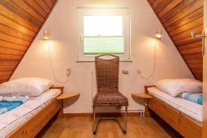 una habitación con 2 camas y una silla en un ático en 50156..., en Harlesiel