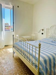 um quarto com uma cama, uma mesa e uma janela em A casa di Mario e Nenè em Viareggio