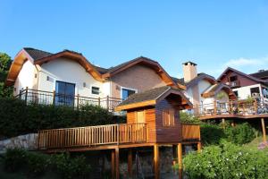 a house with a wrap around deck in front of it at Casa Primavera by The Lodges in Campos do Jordão
