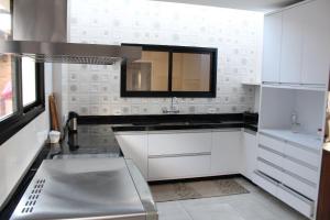 a white kitchen with a sink and a mirror at Casa Primavera by The Lodges in Campos do Jordão +36 photos