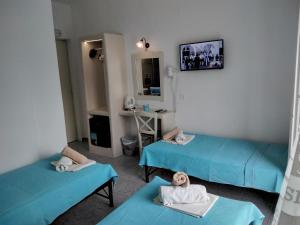 Habitación hospitalaria con 2 camas y espejo en Nikolas ios Village, en Ios Chora