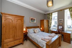 a bedroom with a bed with wooden furniture and a desk at Horsemarket Apartment in Kelso