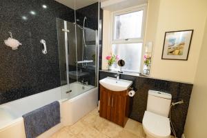 a bathroom with a toilet and a sink and a shower at Horsemarket Apartment in Kelso