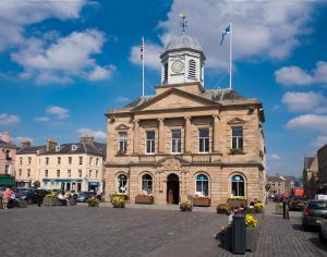 a building with a clock tower on top of it at Horsemarket Apartment in Kelso