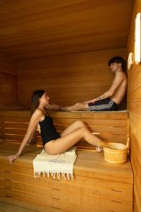 a man and a woman sitting in a sauna at Hotel Bahamas in Lido di Savio