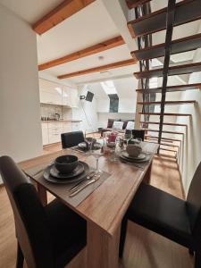 una sala da pranzo con tavolo e sedie in legno di San Lux Dunavska a Novi Sad