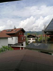 una vista de los tejados de los edificios con montañas en el fondo en Haus & Heim Ferienwohnung, en Oberstdorf