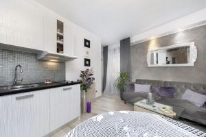uma cozinha e uma sala de estar com um sofá em Apartments Casa Ivona em Rovinj