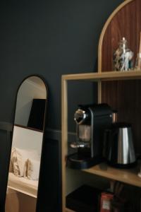 um quarto com um espelho e uma cafeteira numa prateleira em Hotel & Spa Savarin - Rijswijk, The Hague em Rijswijk