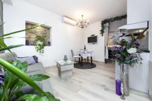 uma sala de estar com um sofá e uma mesa em Apartments Casa Ivona em Rovinj