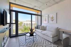 a living room with a couch and a large window at SIX ON N - Fluent Serviced Apartments in Cape Town