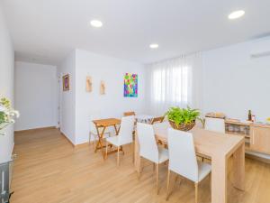 a dining room with a wooden table and white chairs at Cubo's Hostal William's Sunny 2 with Breakfast in Torre de Benagalbón