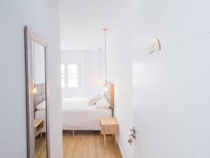 a white bedroom with a bed and a mirror at Cubo's Hostal William's Sunny 4 with Breakfast in Torre de Benagalbón