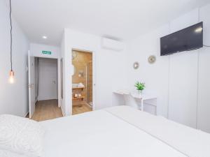 a white bedroom with a bed and a desk at Cubo's Hostal William's Sunny 4 with Breakfast in Torre de Benagalbón