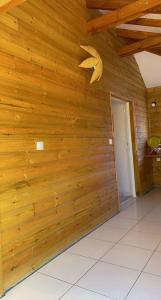 a room with a wooden wall with a door at Banana EcoLodge in Saint-François