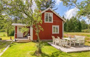 una casita roja pequeña con mesa y sillas en 3 Bedroom Lovely Home In Mellerud, en Mellerud
