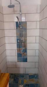 um chuveiro na casa de banho com azulejos brancos em Banana EcoLodge em Saint-François