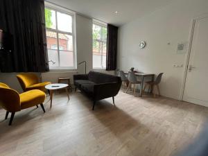 een woonkamer met een bank, stoelen en een tafel bij Appartementen het Centrum in Domburg