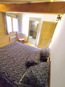 - une chambre avec un lit et une chaise dans l'établissement RESIDENCE SASKYA, à Samoëns