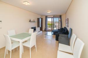 Una sala de estar con una mesa y sillas y un sofá. en Orquidea, en San Juan de los Terreros