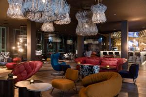 a lobby with chairs and tables and chandeliers at Motel One Mannheim in Mannheim