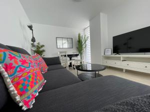 a living room with a couch and a tv at LHOME CÁDIZ in Cádiz