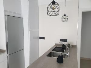 a kitchen with white cabinets and a sink at LHOME CÁDIZ in Cádiz