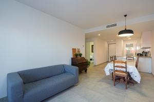 Una sala de estar con un sofá azul y una mesa. en Salvia, en San Juan de los Terreros