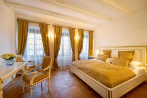 a bedroom with a bed and a table and chairs at Spa Beerland Chateaux – U Zlaté Hrušky / At Golden pear in Prague