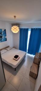 a bedroom with a bed and a blue curtain at VBH APARTMENT PACEVILLE ST. JULIAN'S in Paceville