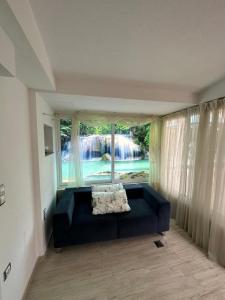 a living room with a couch in front of a window at Sea Wave House in Hanioti