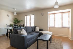 a living room with a couch and a table at Spacious, Modern, Fully Furnished Apartment - 2 FREE PARKING Spaces - 8 min LGW Airport in Crawley