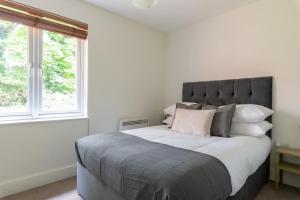 sypialnia z dużym łóżkiem i dużym oknem w obiekcie Spacious, Modern, Fully Furnished Apartment - 2 FREE PARKING Spaces - 8 min LGW Airport w mieście Crawley