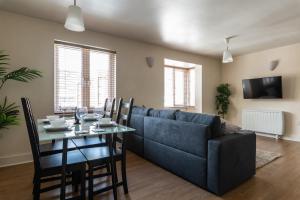 a living room with a blue couch and a table at Spacious, Modern, Fully Furnished Apartment - 2 FREE PARKING Spaces - 8 min LGW Airport in Crawley
