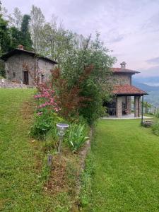 a garden in front of a house with a bird feeder at Birillina Guest House di Laura Reni in Poggio