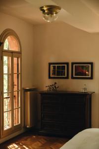 a bedroom with a bed and a dresser and a window at Le dimore de Il borgo del balsamico in Albinea